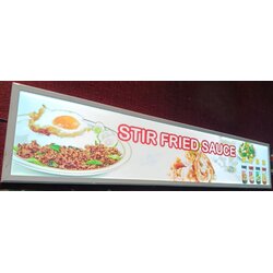 ป้ายในภาพเป็นป้ายไฟเมนู Slim Lightbox ของร้านอาหารที่จำหน่ายอาหารผัดซอส (STIR FRIED SAUCE)