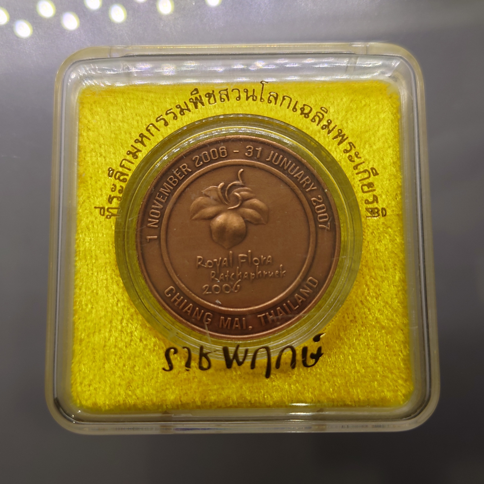 เหรียญที่ระลึกมหกรรมพืชสวนโลกเฉลิมพระเกียรติ ราชพฤกษ์ ร9 (เหรียญ Royal Flora) เนื้อทองแดงพ่นทรายรมดำ ปี2549 พร้อมกล่องเดิม หายาก