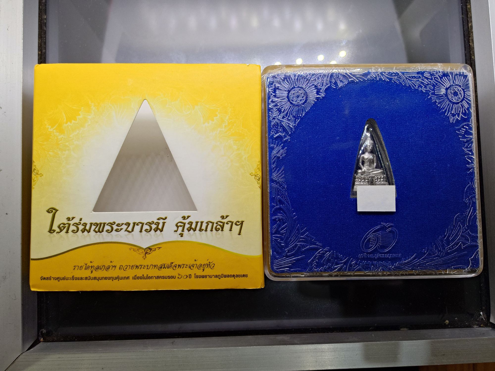 พระพุทธรูปคุ้มเกล้าฯ ภปร. เนื้อเงิน ชุบทอคำขาว พิมพ์เล็ก "ใต้ร่มพระบารมี คุ้มเกล้าฯ" ที่ระลึก 60 ปี โรงพยาบาลภูมิพลฯ ปี2552 พร้อมตลับเดิม