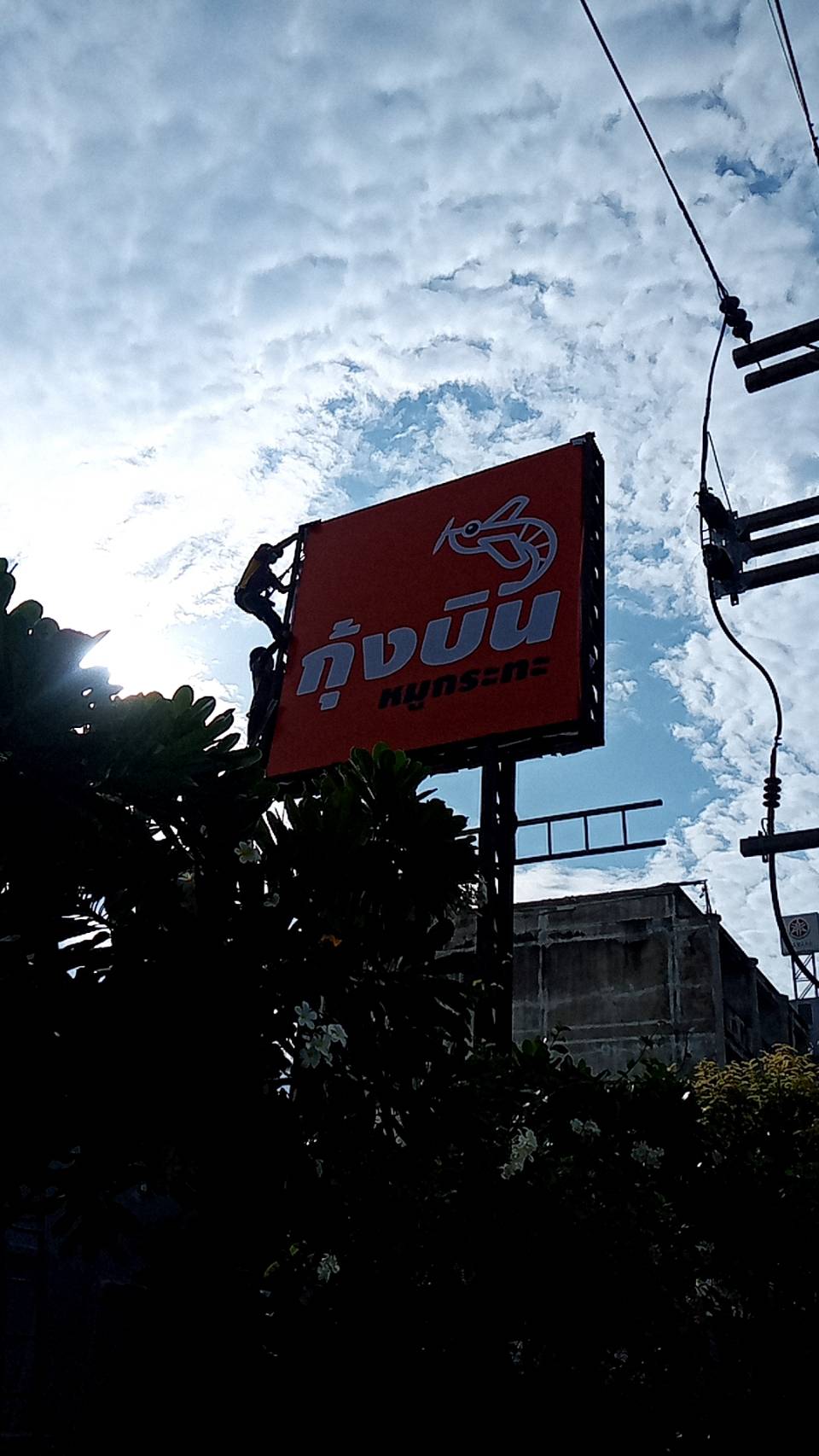 ป้ายไวนิลขึงโครงสี่เหลี่ยมงานกุ้งบิน บนป้ายทาวเวอร์