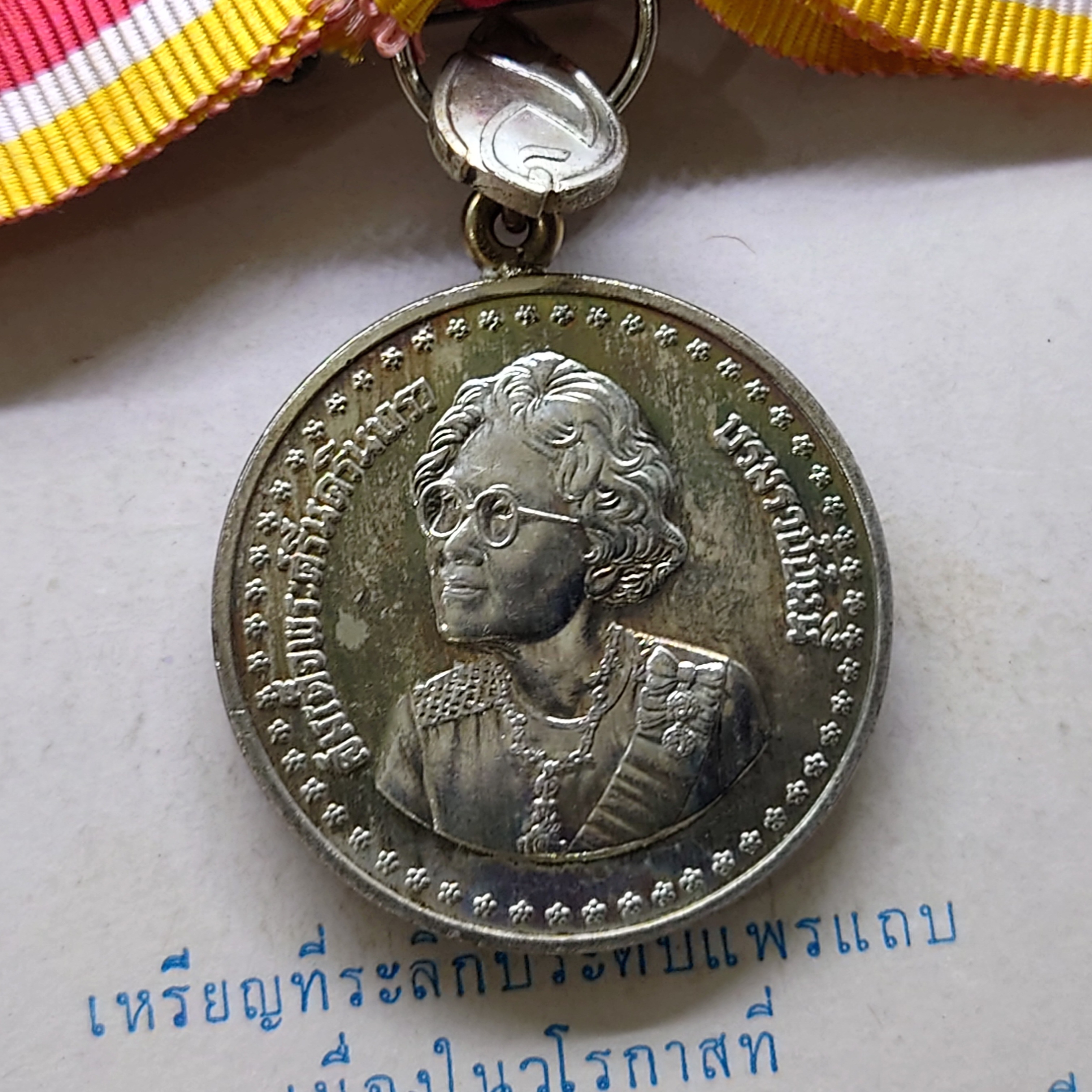 เหรียญที่ระลึกประดับแพรแถบ เนื้อเงิน สมเด็จย่า 84 พรรษา พ.ศ.2527 แบบหญิง