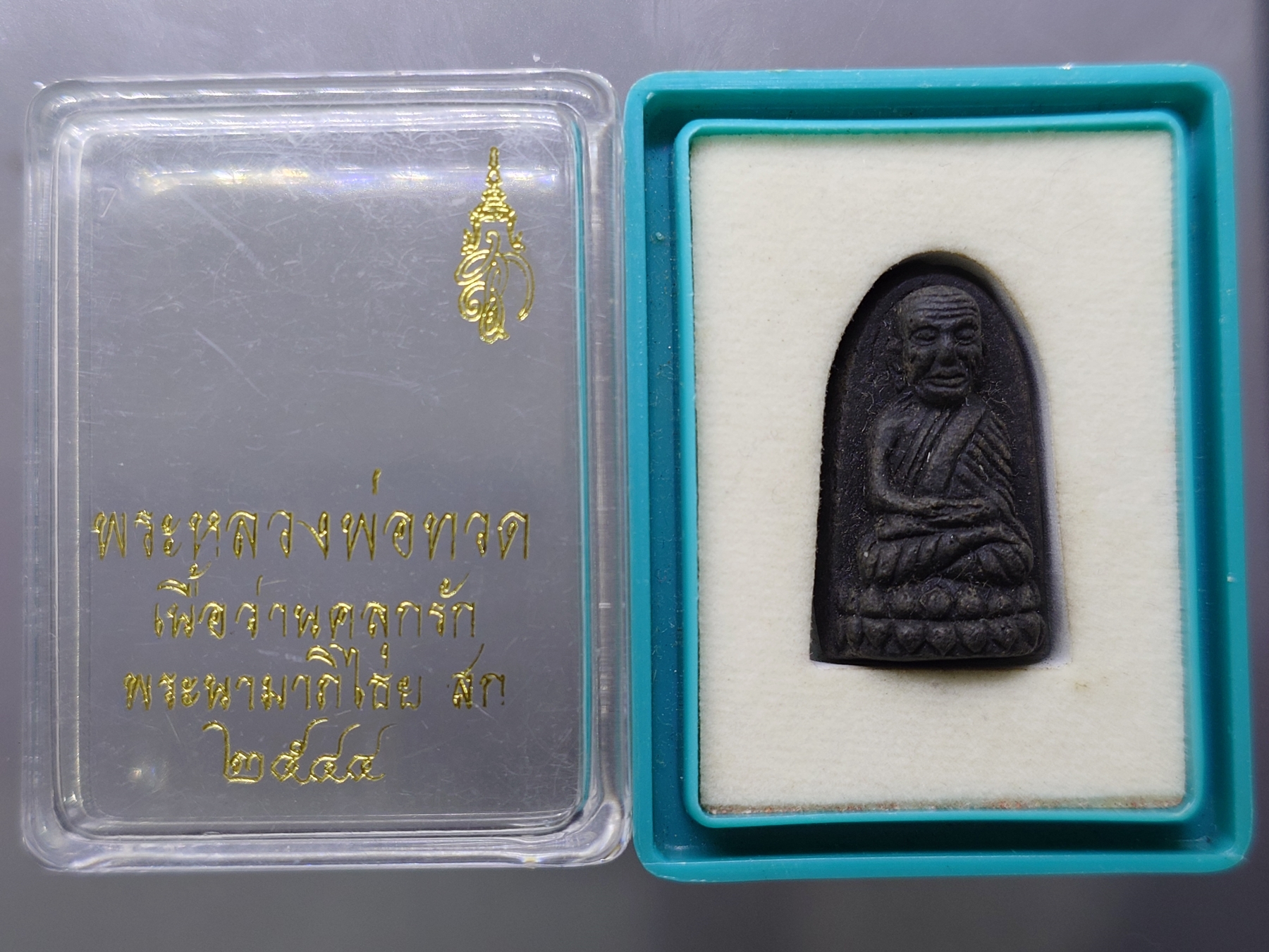 หลวงพ่อทวด พระนามาภิไธย สก. พิมพ์พระรอด เนื้อว่านคลุกรัก วัดห้วยมงคล ปี 2544 พร้อมกล่องเดิม