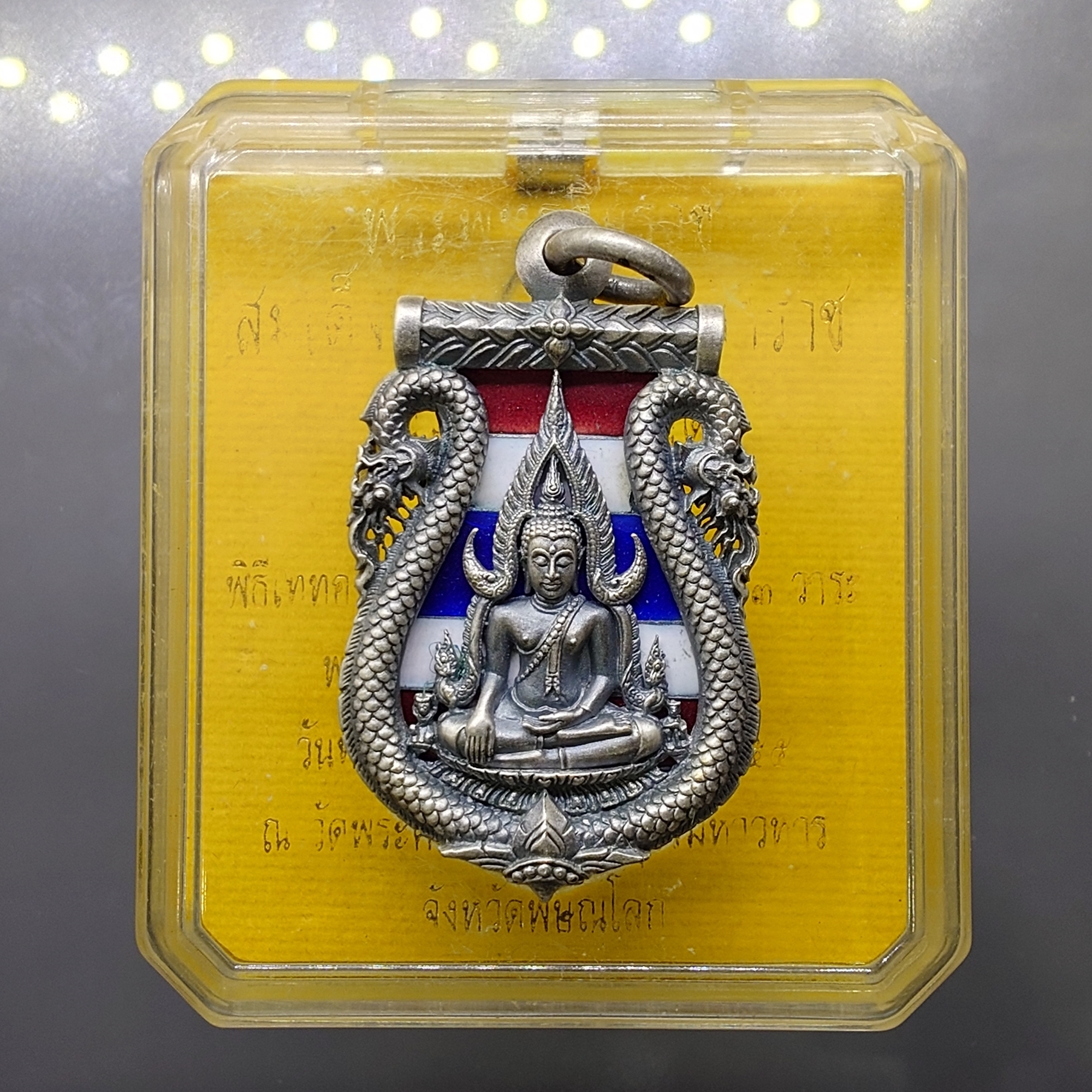เหรียญพระพุทธชินราช เสมาฉลุลาย ยกซุ้มพญานาค รุ่นมหาจักรพรรดิ เนื้อบรอนซ์ลงยาราชาวดี สีธงชาติ ชุบเงินซาติน วัดพระศรีรัตนมหาธาตุฯ ปี2555 พร้อมกล่องเดิม