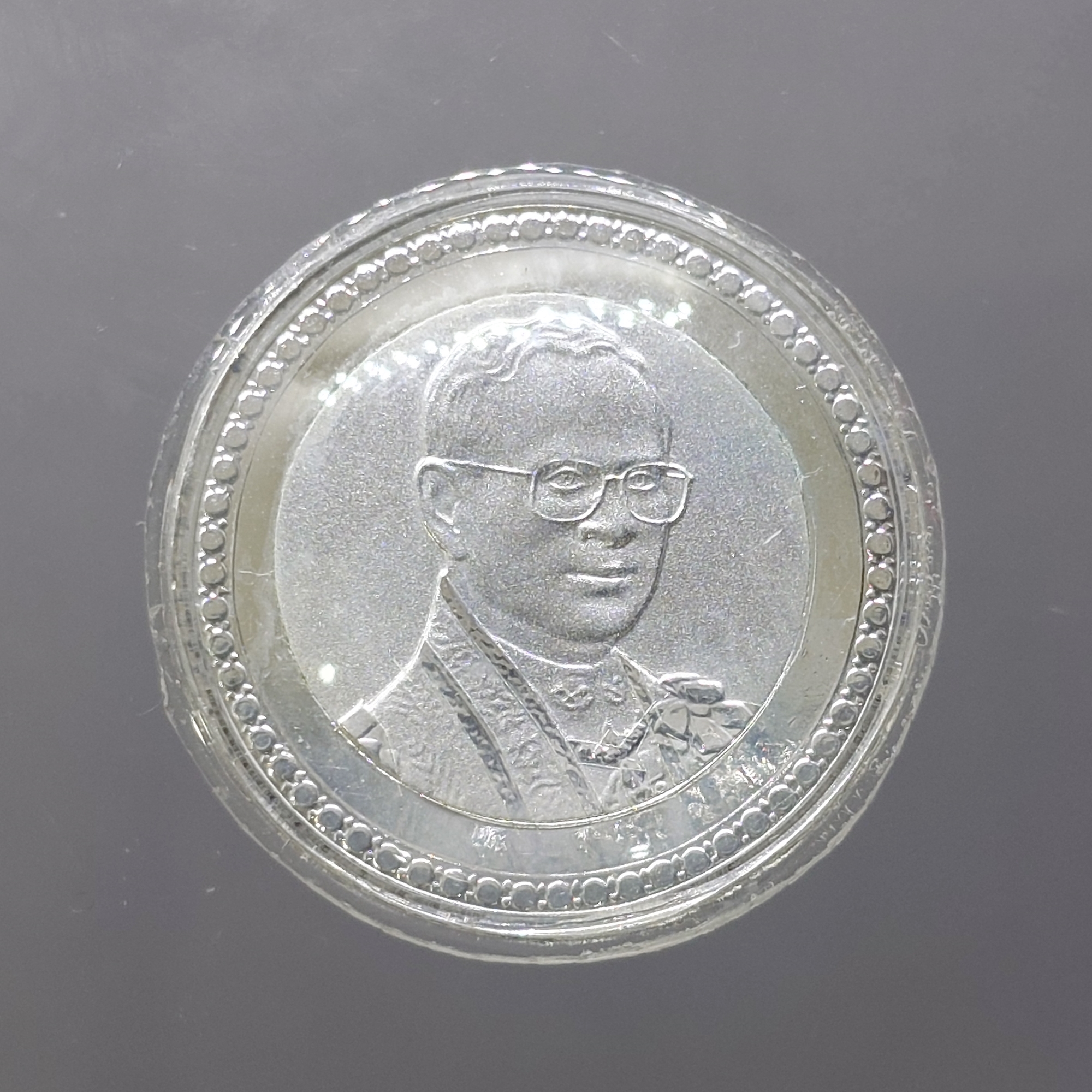 เหรียญ 10 บาท สองสี กาหลั่ยเงิน ขัดเงาพ่นทราย ที่ระลึกครองราชย์ครบ 60 ปี รัขกาลที่9 ปี2549 พร้อมเลี่ยมกันน้ำ