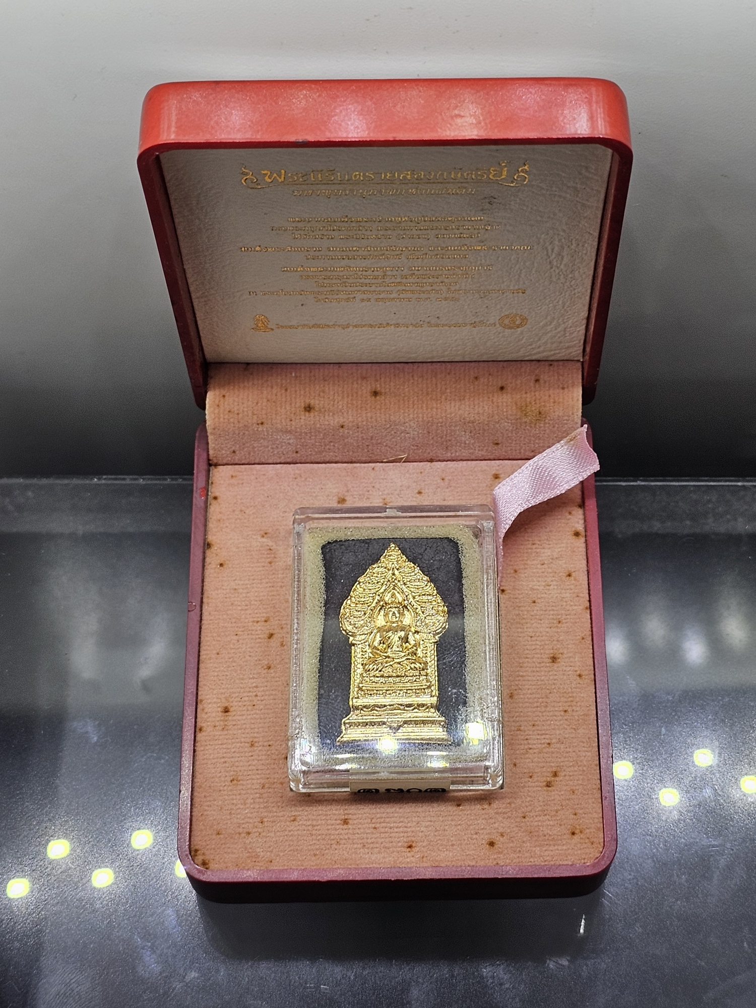 พระนิรันตรายสองกษัตริย์ มหาพุทธานุภาพแห่งแผ่นดิน เนื้อผง (สีดำ) หน้าปัดทอง หลังฝังนวโลหะชุบนาก (พระปรมาภิไธยย่อสองกษัตริย์) ปี2552 พร้อมกล่อง