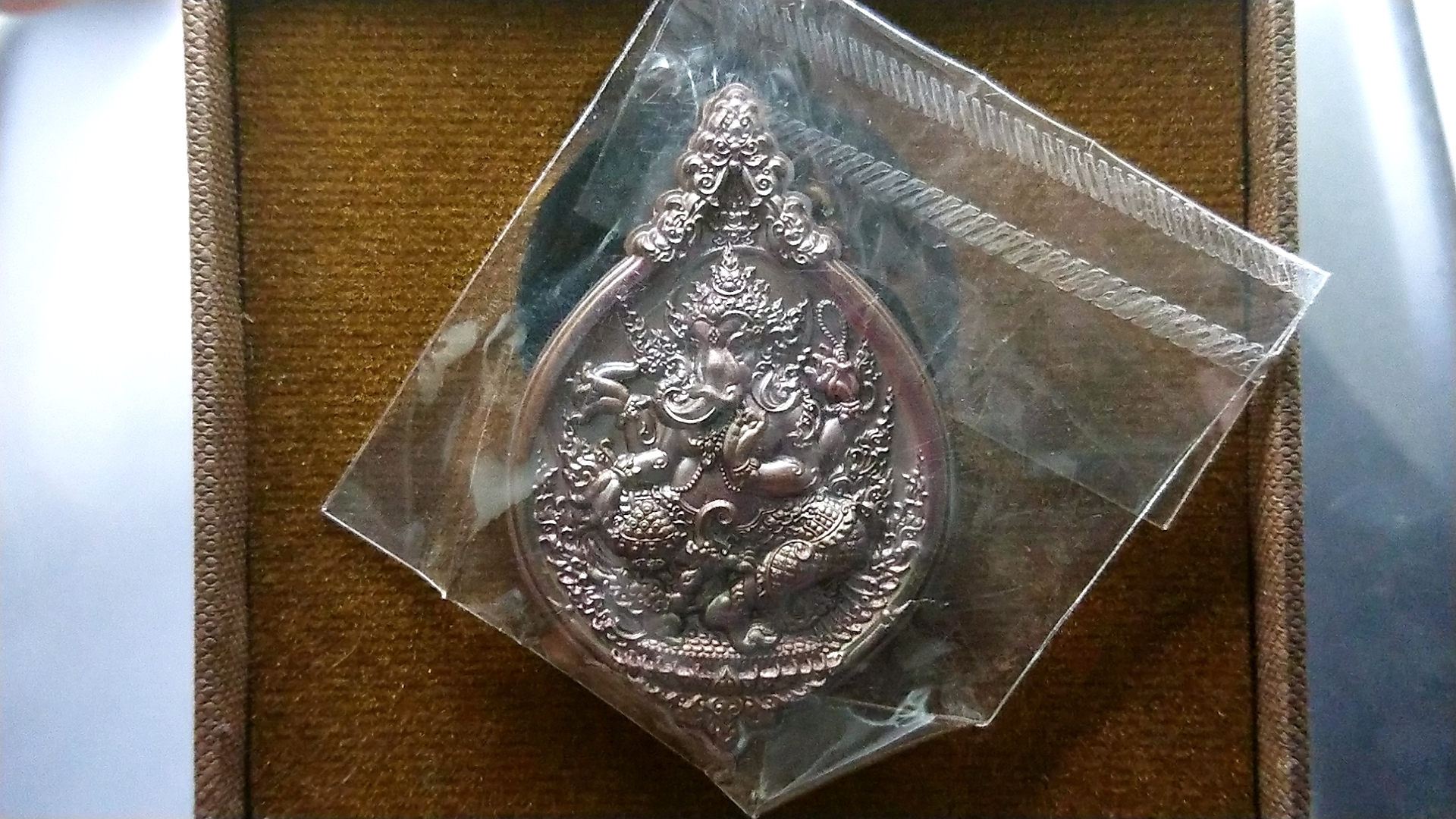 เหรียญพระพิฆเนศสุขสบาย เนื้อทองแดงประกายรุ้ง หลวงปู่ยูร วัดหนองป่าหมาก สระแก้ว