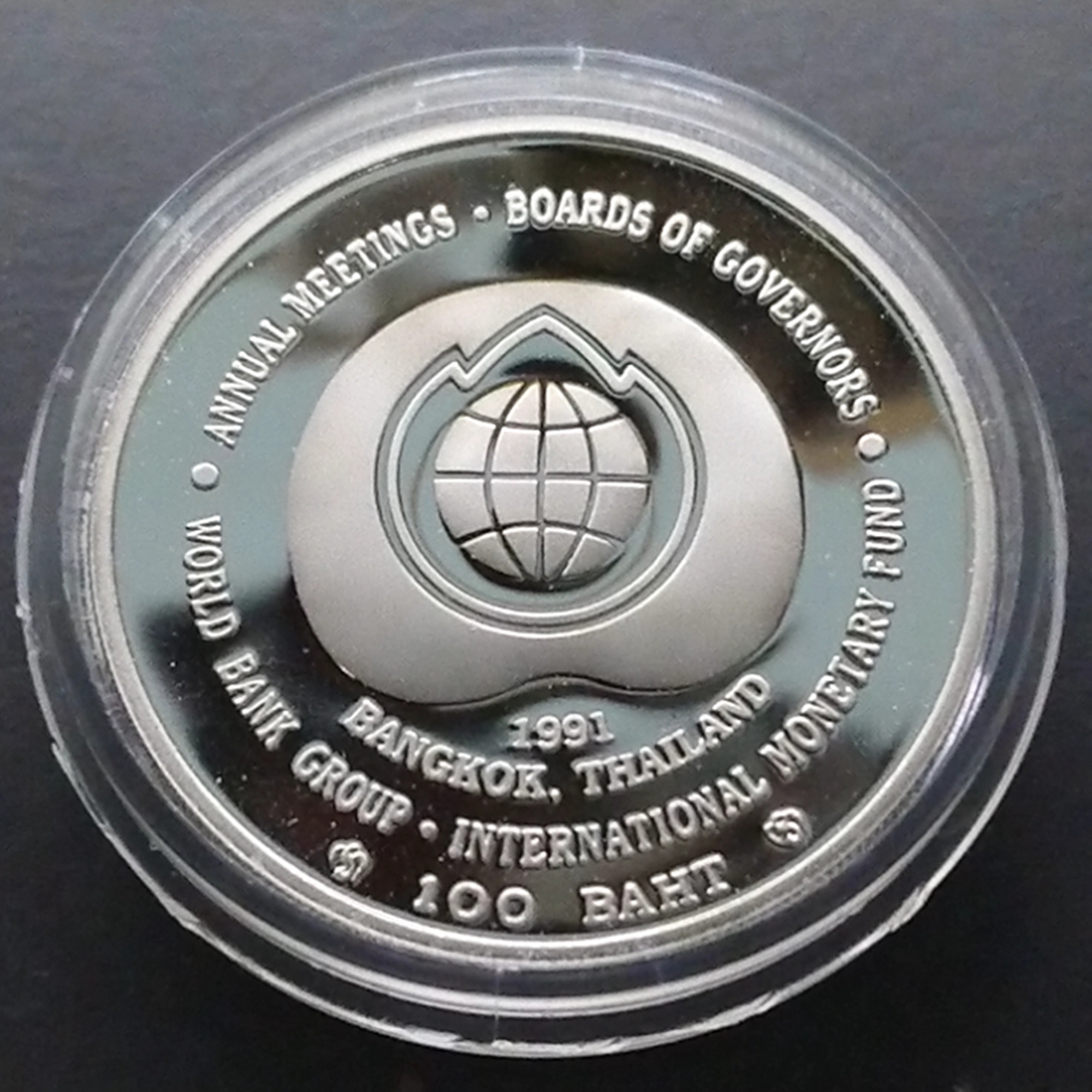 เหรียญ 100 บาท นิเกิลขัดเงา เวิลด์แบงก์ ที่ระลึกการประชุมสภาผู้ว่าการธนาคารโลก และกองทุนการเงินระหว่างประเทศ พ.ศ.2534 พร้อมใบเซอร์กล่องหนัง