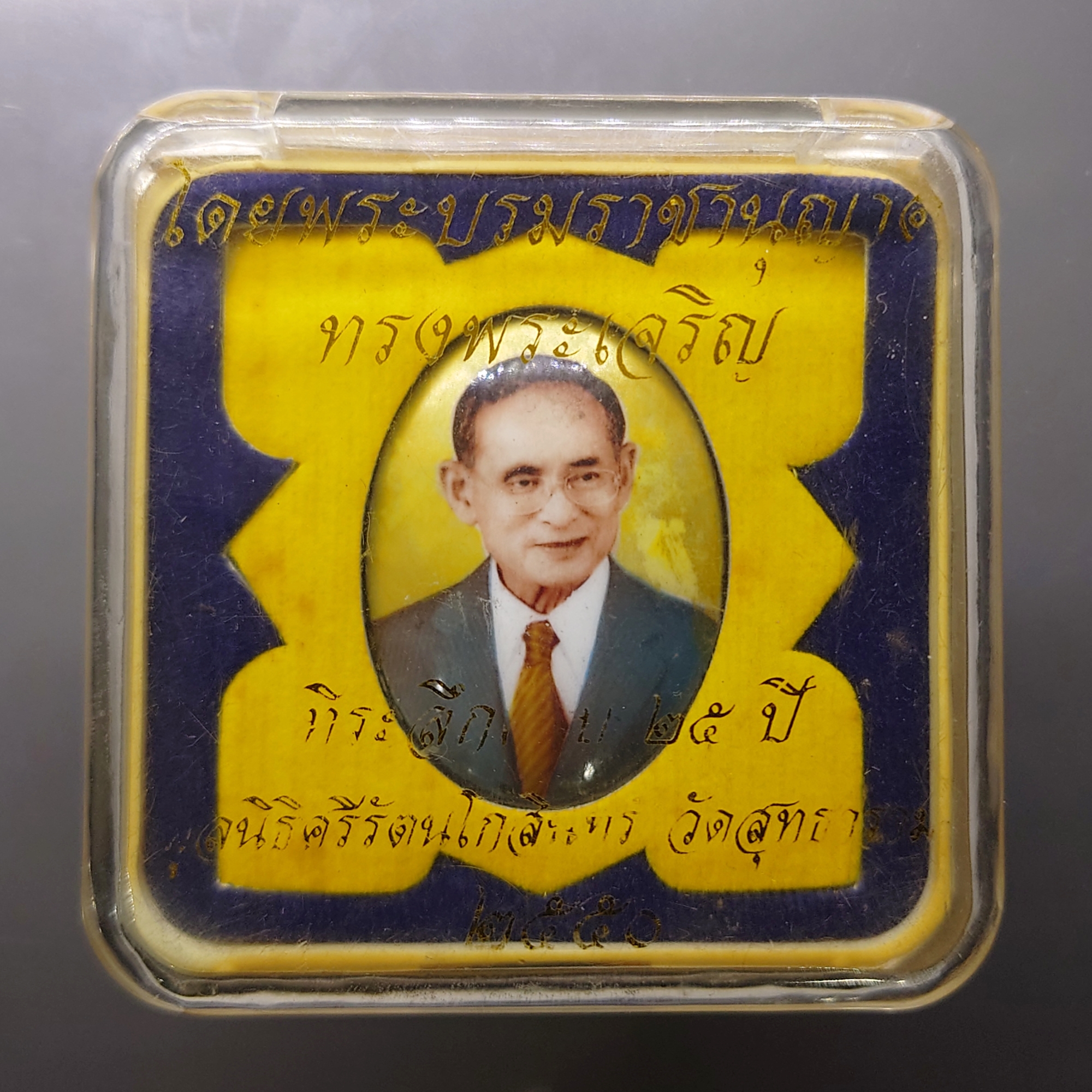 ล็อกเก็ตในหลวงรัชกาลที่ 9 พิมพ์รีใหญ่ ฉากสีทอง หลังสแตนเลส บรรจุมวลสารจิตรลดา ฝังพระยอดธง มงคลระลึกครบ 25 ปี มูลนิธิศรีรัตนโกสินทร์ วัดสุทธาราม พ.ศ.2550 ตลับเดิม