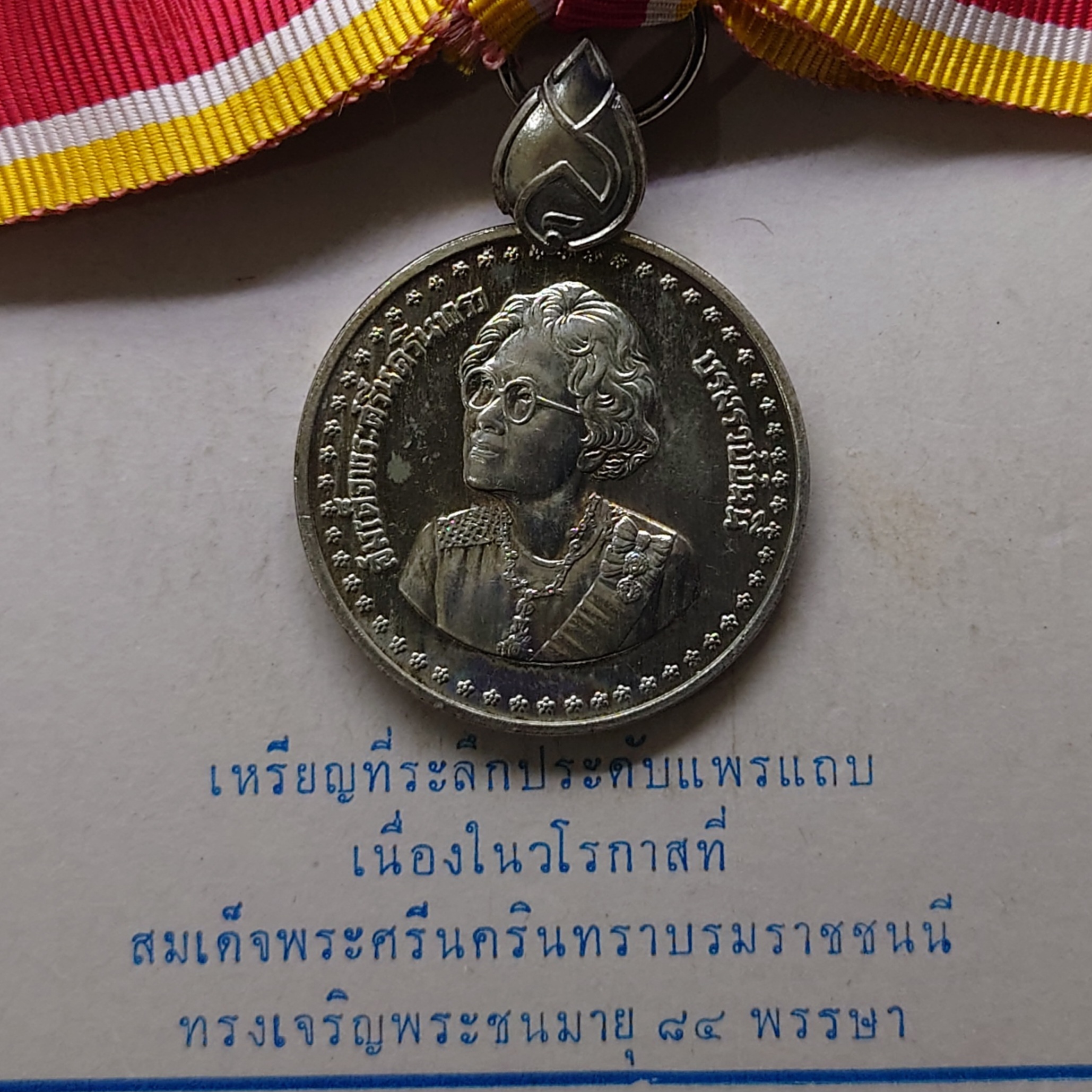 เหรียญที่ระลึกประดับแพรแถบ เนื้อเงิน สมเด็จย่า 84 พรรษา พ.ศ.2527 แบบหญิง