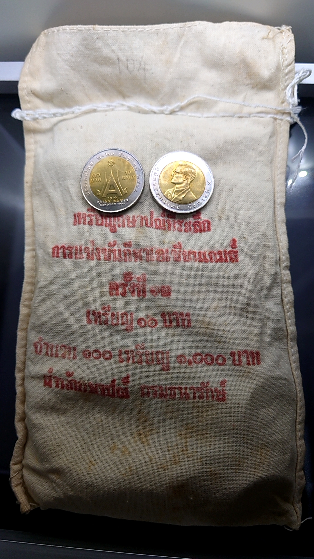 เหรียญยกถุง 100 เหรียญ เหรียญ 10 บาทสองสี ที่ระลึกเอเชี่ยนเกมส์ครั้งที่ 13 ไม่ผ่านใช้