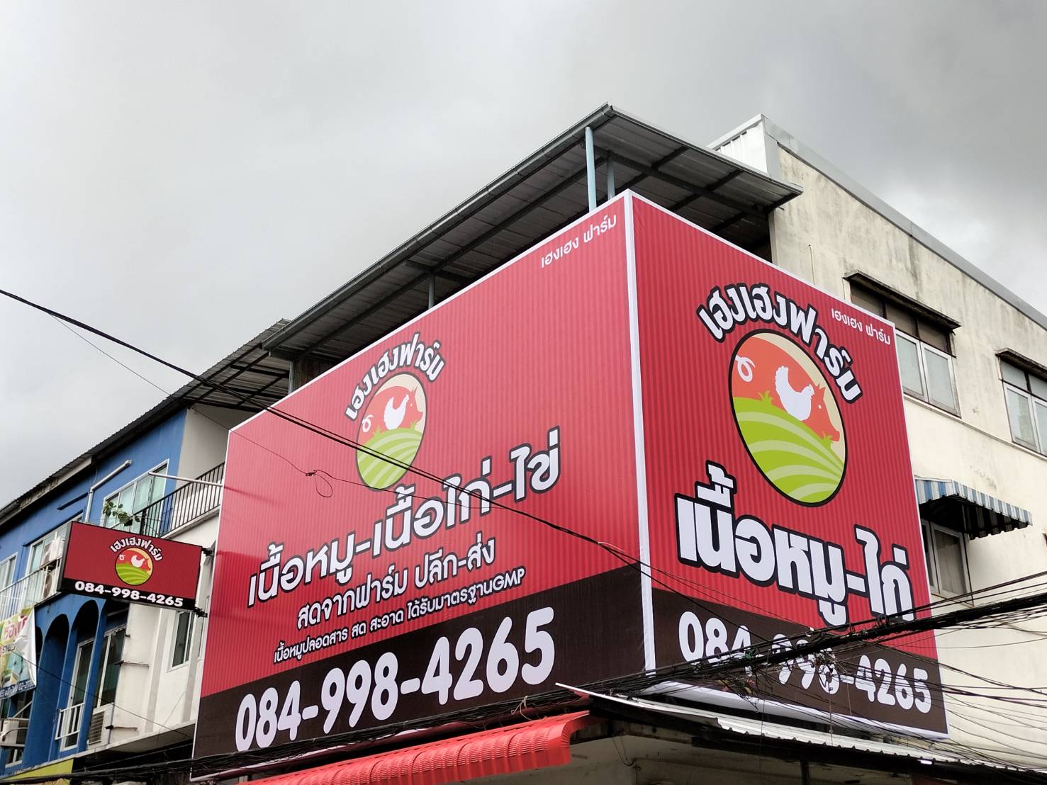 ป้ายไวนิลขึงโครงติดหน้าตึก งานเฮงเฮงฟาร์ม
