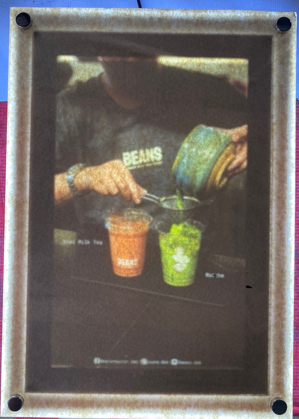 ป้ายในภาพเป็นป้ายไฟเมนูของร้าน BEANS ชานมสไตล์พรีเมียม