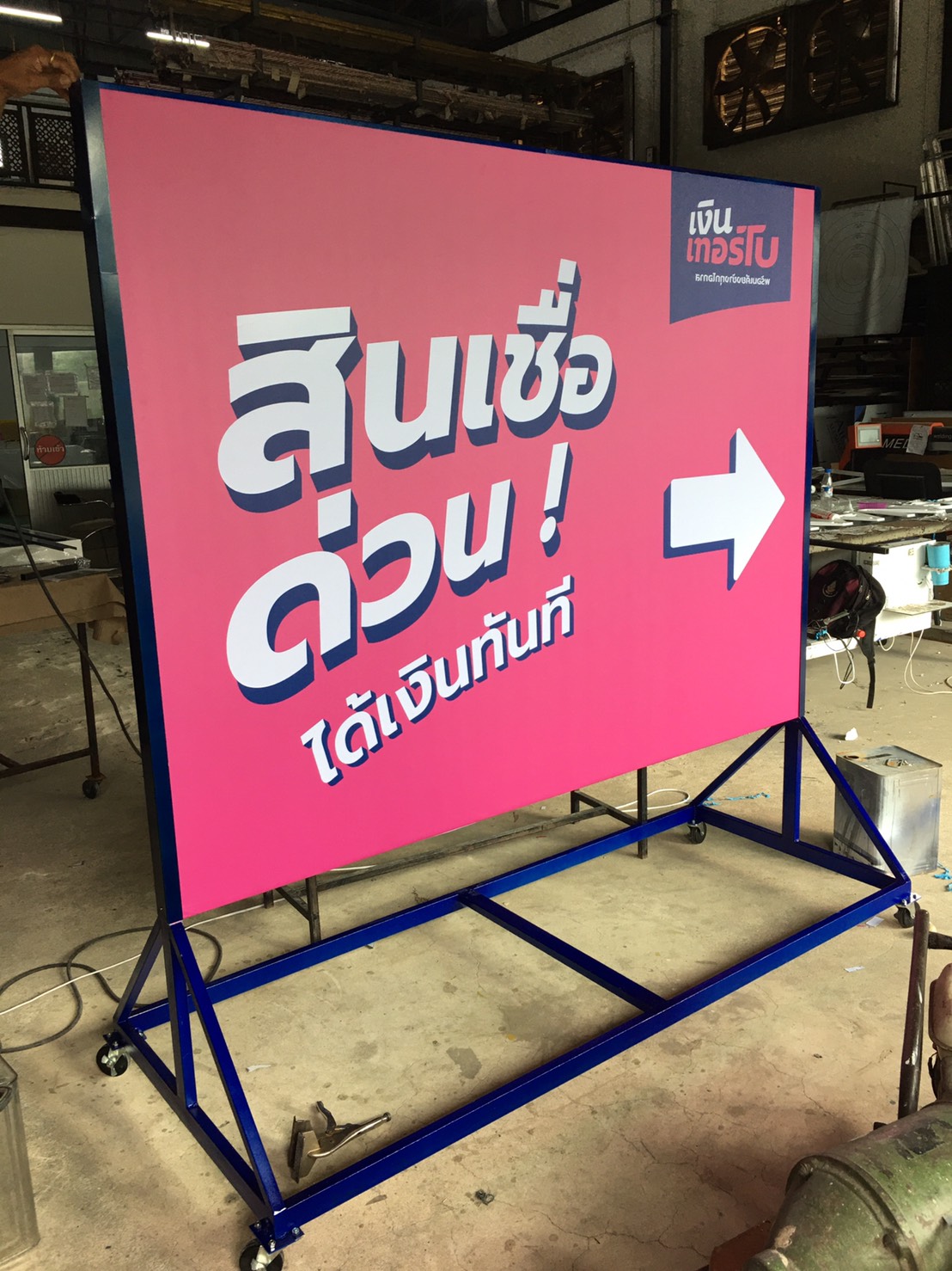 ป้ายไวนิลขึงโครงล้อเลื่อน โครงเหล็กพ่นสีน้ำเงิน งานสินเชื่อเงินเทอร์โบ