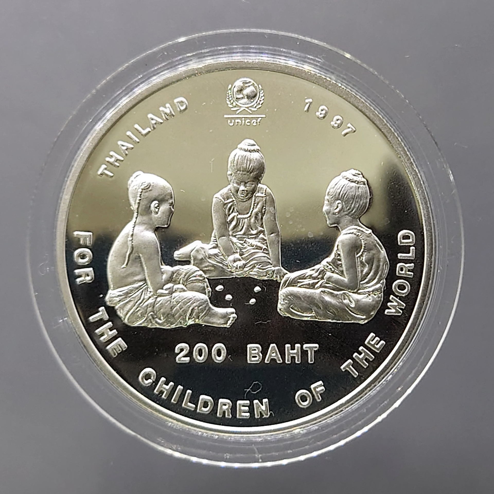 เหรียญเงินขัดเงา 200 บาท เด็กเล่นหมากเก็บ ที่ระลึก 50 ปี กองทุนสงเคราะห์เด็กแห่งสหประชาชาติ UNICEF พ.ศ.2540