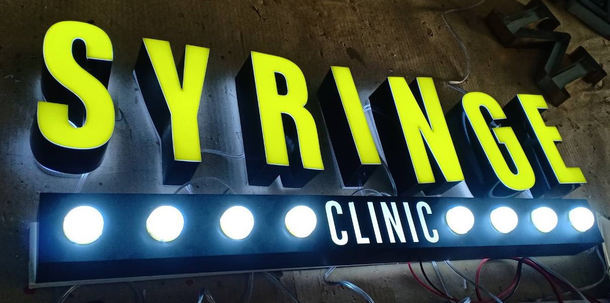 ป้ายไฟ SYRINGE CLINIC | ป้ายตัวอักษรลอยไฟออกหน้า + หลอดหัวกระสุน สไตล์คลินิกทันสมัย