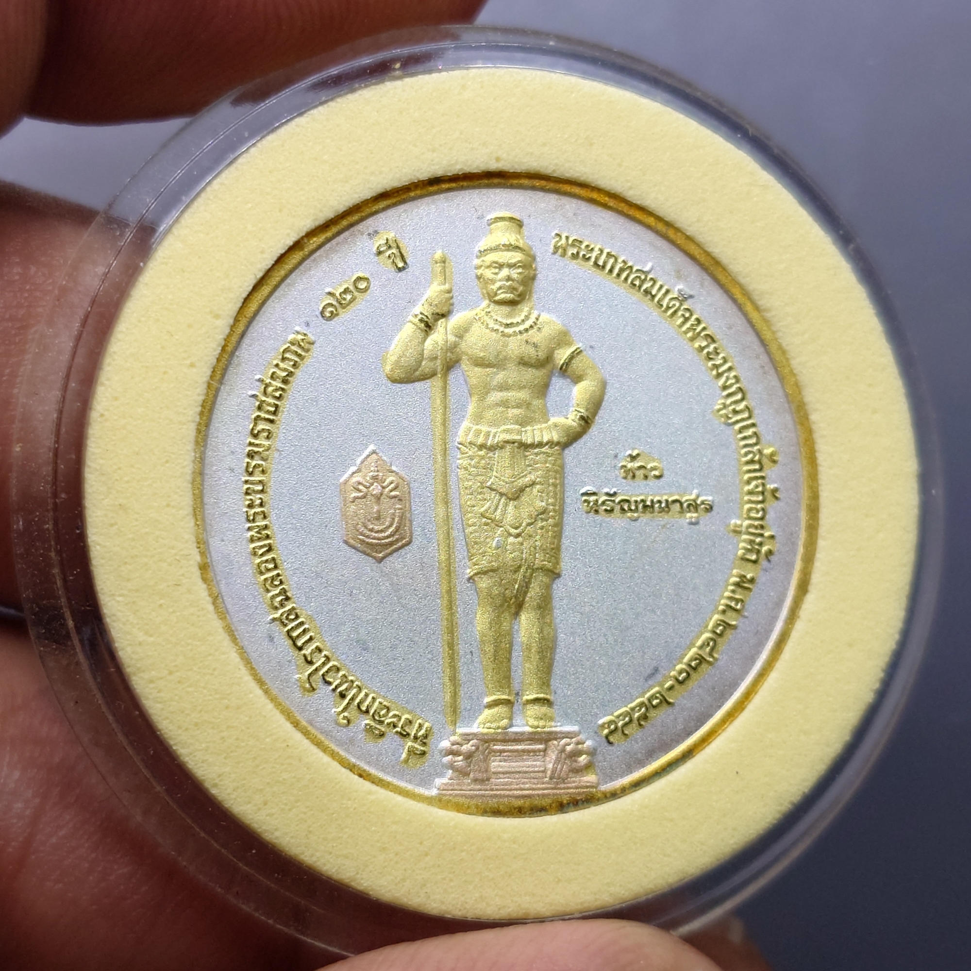 เหรียญพระนิรโรคันตราย หลัง ท้าวหิรัญพนาสูร เนื้อโลหะชุบสามกษัตริย์ ที่ระลึก 102 ปีพระราชสมภพ พระมงกุฎเกล้าเจ้าอยู่หัว 2544