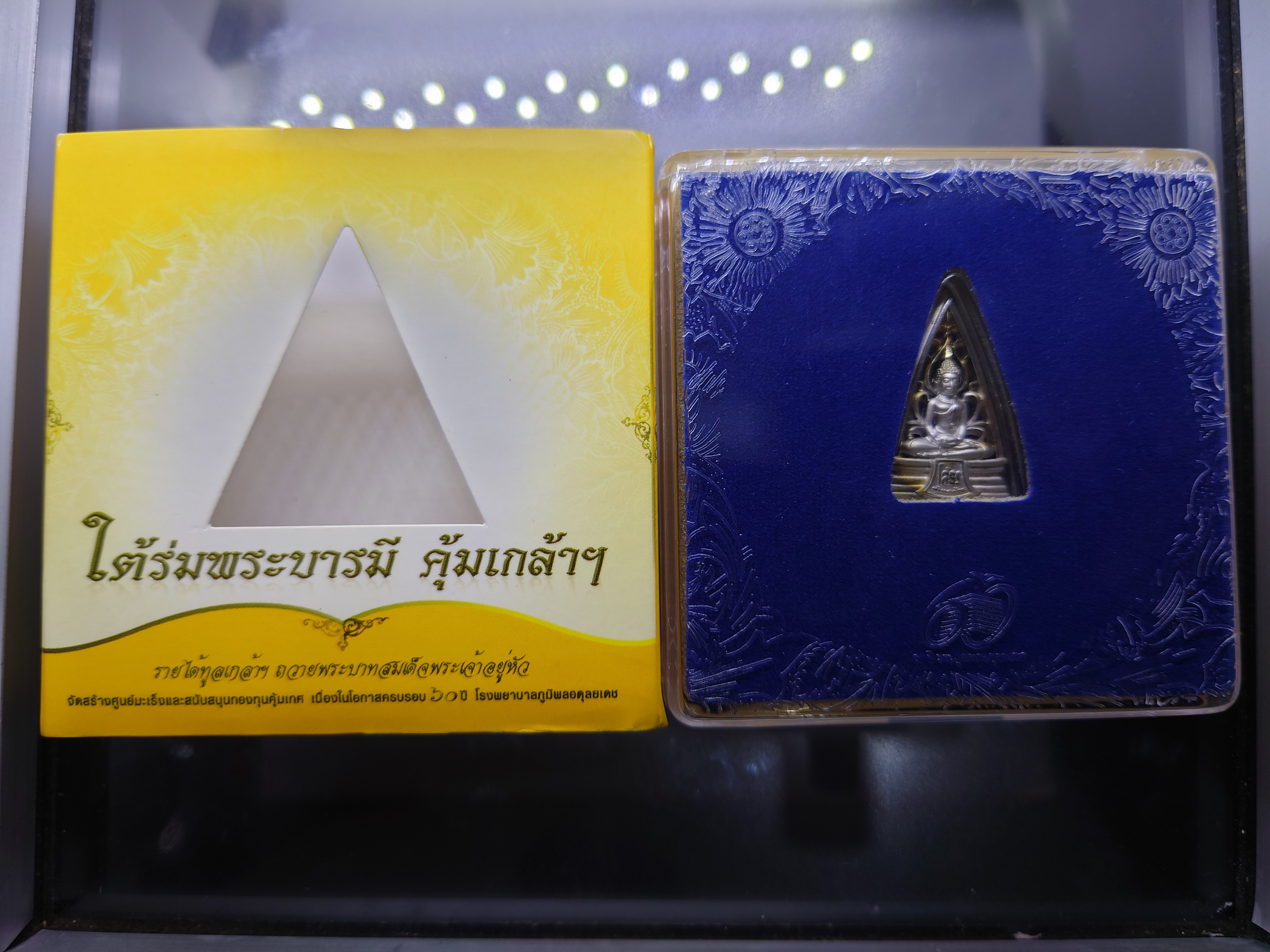 เหรียญพระพุทธโสธร รูปสามเหลี่ยม เนื้อเงิน ชุบทองคำขาว "ใต้ร่มพระบารมี คุ้มเกล้าฯ" ที่ระลึก 60 ปี โรงพยาบาลภูมิพลฯ ปี2552 พร้อมตลับเดิม