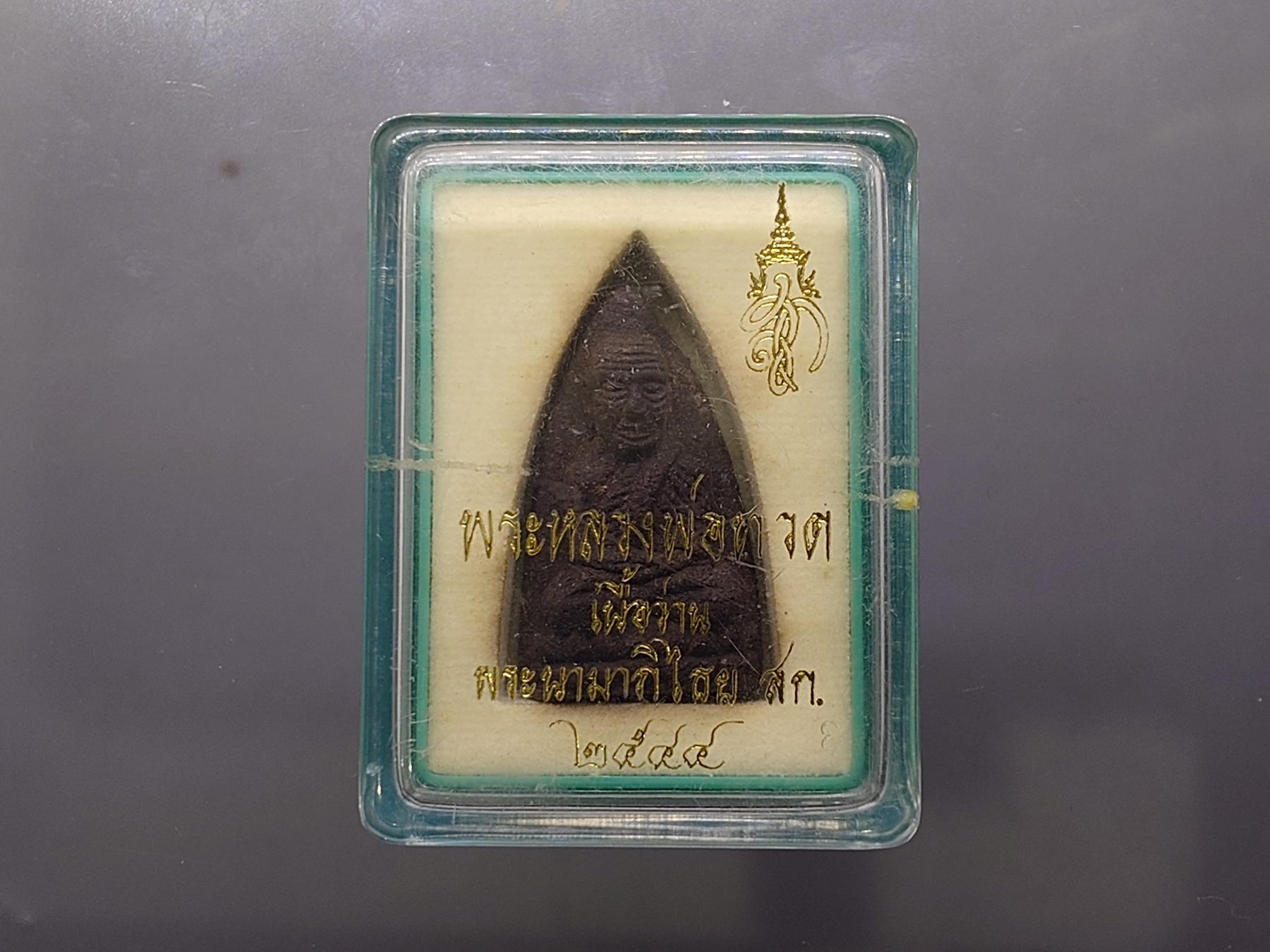 หลวงพ่อทวด พระนามาภิไธย สก. พิมพ์เตารีด เนื้อว่านคลุกรัก วัดห้วยมงคล ปี 2544 พร้อมกล่องเดิม