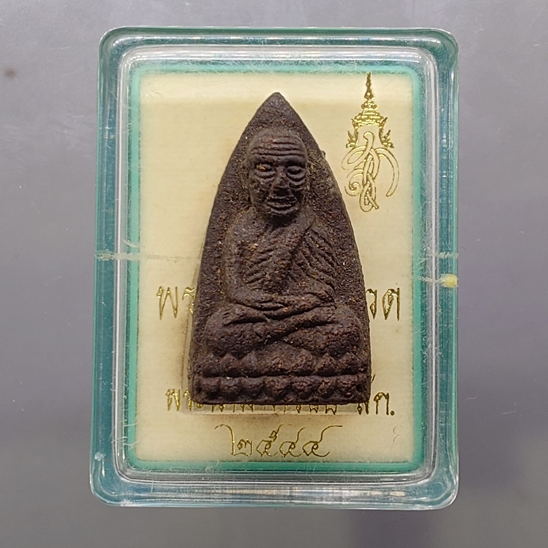 หลวงพ่อทวด พระนามาภิไธย สก. พิมพ์เตารีด เนื้อว่านคลุกรัก วัดห้วยมงคล ปี 2544 พร้อมกล่องเดิม