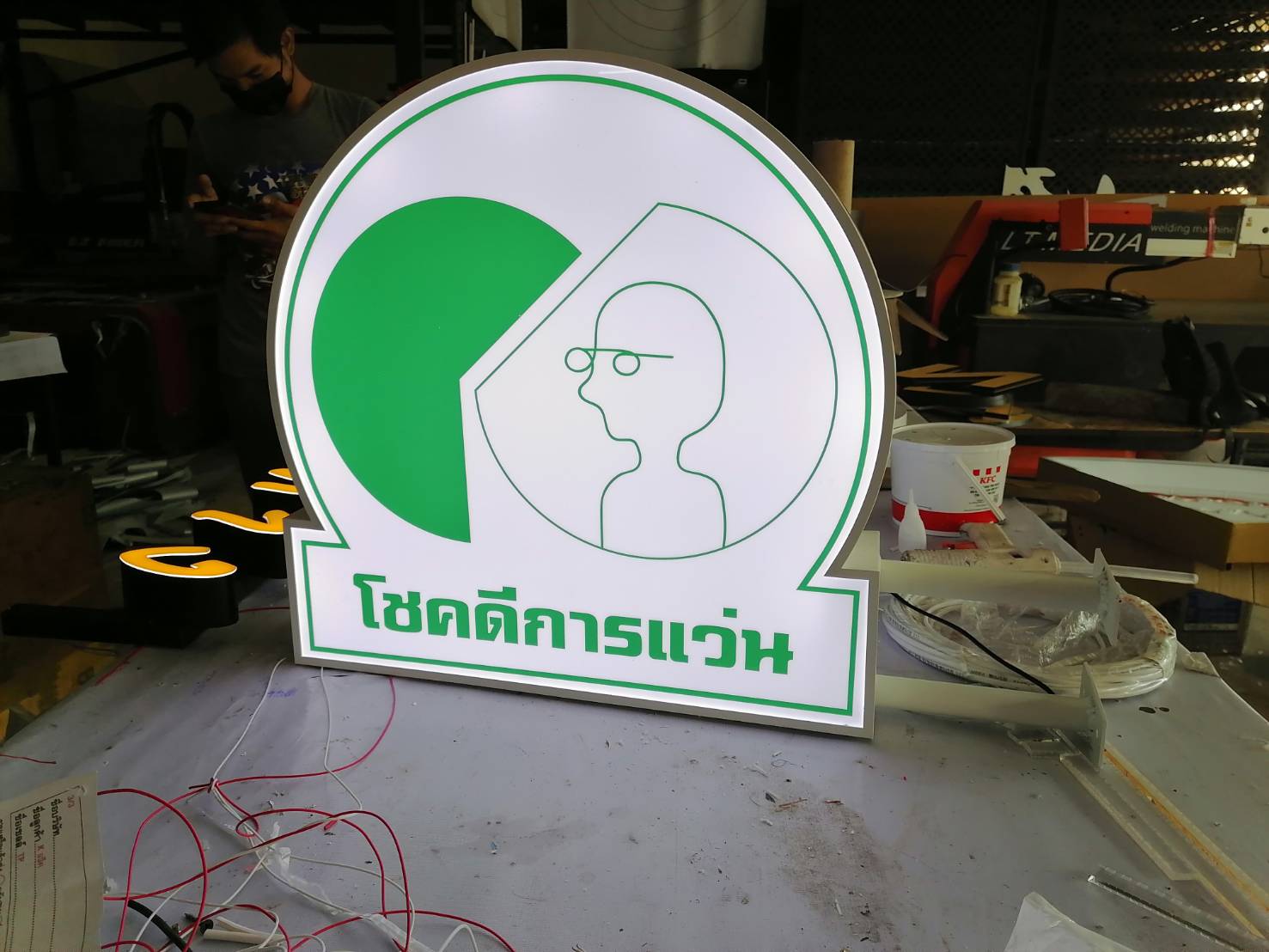 ป้ายตู้ไฟขายื่นขอบอลูมิเนียมพ่นสีขาว งานโชคดีการแว่น